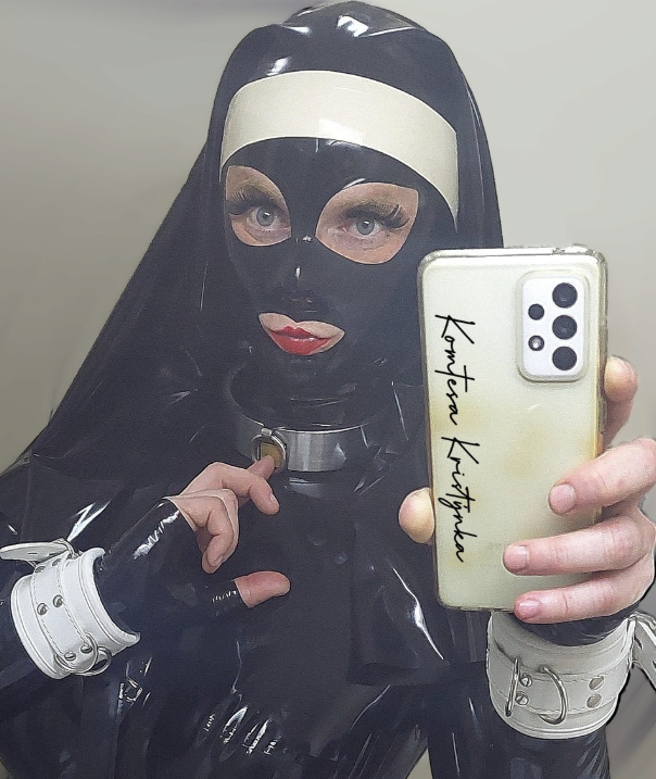 Komtesa Kristýnka si pořizuje selfie v sexy černém jeptiškovém oblečení s černou latexovou maskou přes obličej a řetízkem na krku.