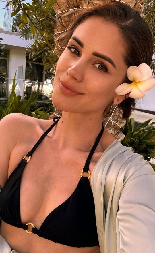 @littlecaprice si dělá selfie v černé podprsence a bílém saku.