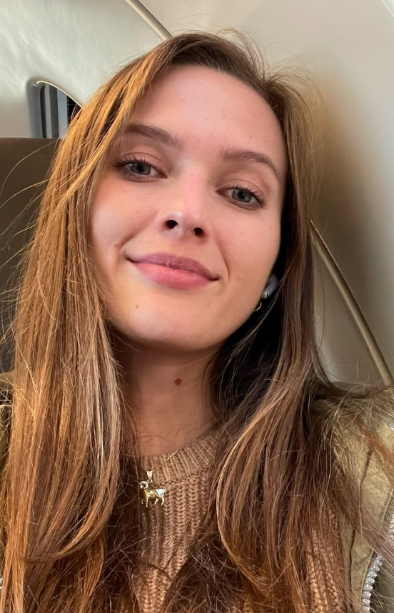 Stacy Cruz, která si fotí selfie v autě a má na sobě sexy hnědý top a zlatý náhrdelník.