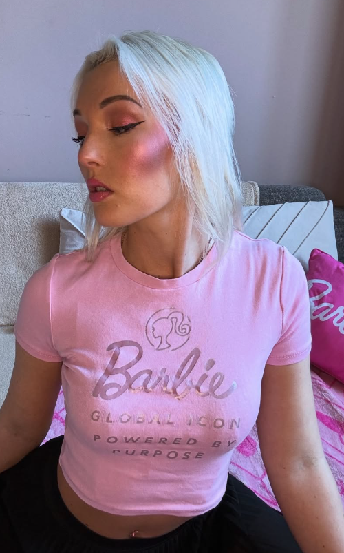 Lovita Fate se fotí na posteli v sexy růžovém crop topu a černé sukni.