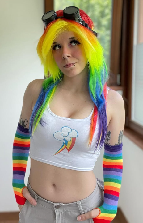 LittleAxl699 se fotí v sexy bílém crop topu, popelavých kalhotách a s vícebarevnými vlasy.