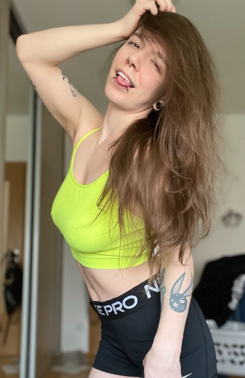 LittleAxl699 se fotí ve svém pokoji a je oblečená v sexy citronově zeleném crop topu a černých upnutých kraťasech.