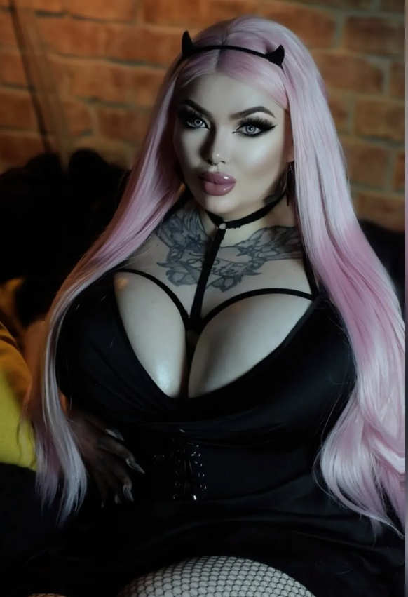 Rebecca Randall se fotí a je oblečená v sexy černých šatech a s malými černými rohy.