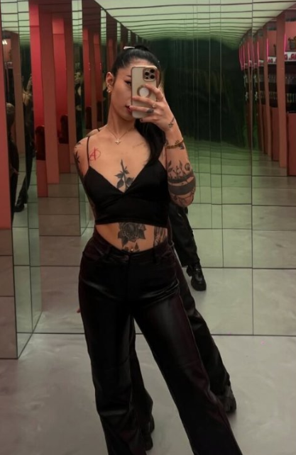 Asia Nina se fotí před zrcadlem v sexy černém crop topu a černých kožených kalhotách.