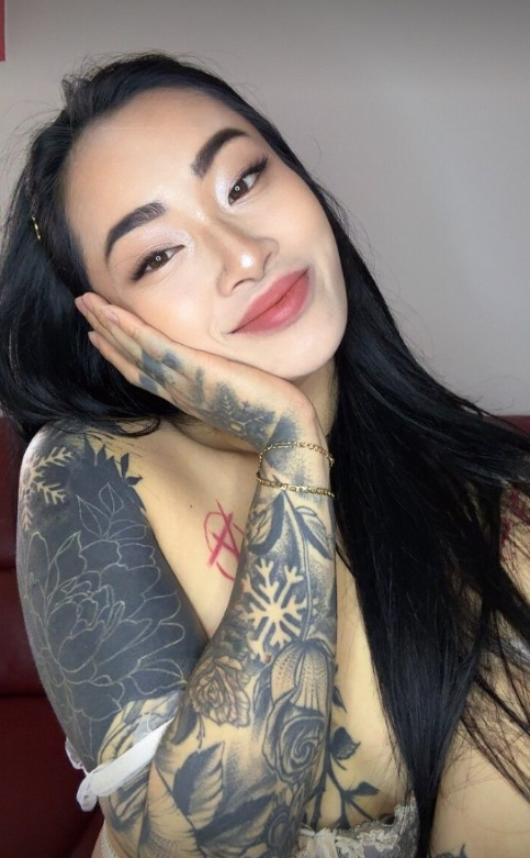 Asia Nina fotí ve svém domě a klade si ruku na tvář.