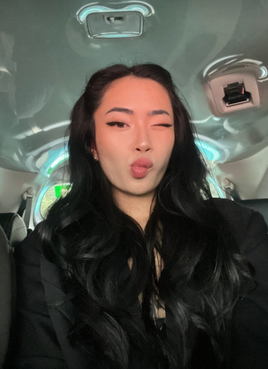 Asia Nina se fotí v autě v sexy černém oblečení a mrká na fotoaparát.