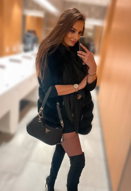 Nicole oblečená v sexy černém oblečení a černé tašce