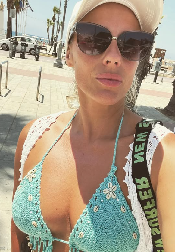 Brittany Bardot v sexy modrém háčkovaném topu, klobouku a slunečních brýlích