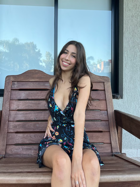 Selena Bloom sedí na lavičce a oblečená v sexy černo-modrém topu