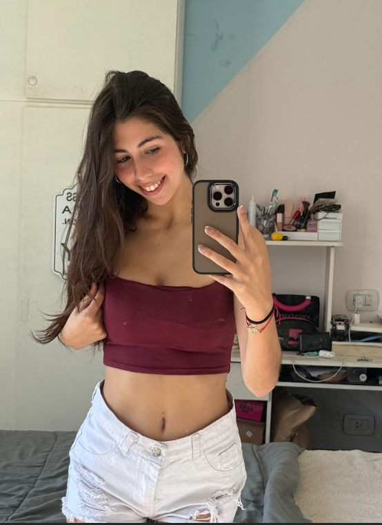 Selena Bloom oblečená v sexy vínovém crop topu a bílých kraťasech