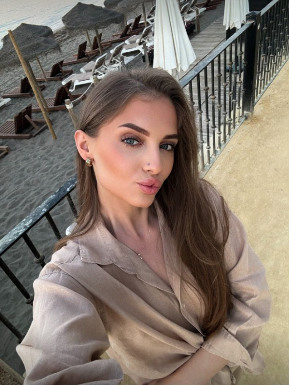 Alžběta oblečená v sexy béžové košili.